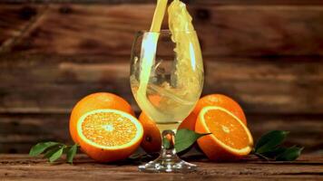 Super slow motion orange juice pours into a glass of spray. Filmed on a high-speed camera at 1000 fps.On a wooden background. video