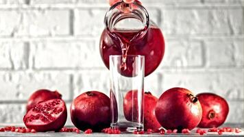 Super slow motion pomegranate juice is poured from jug into glass. On a white background.Filmed on a high-speed camera at 1000 fps. High quality FullHD footage video