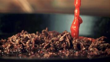 Super slow motion in the mince on the pan drops the tomato sauce.Filmed on a high-speed camera at 1000 fps. Against a dark background. video