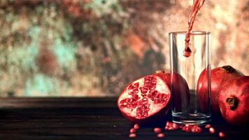 Super slow motion is a jet of pomegranate juice pouring into the glass on the table. Filmed on a high-speed camera at 1000 fps. On the rustic background. High quality FullHD footage video