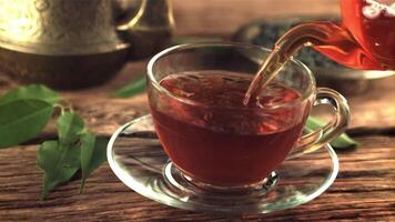 Super slow motion in the cup pour fragrant tea. On a wooden background. Filmed on a high-speed camera at 1000 fps. video