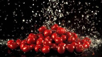 Super slow motion on the fresh cherry droplets of water with splashes. On a black background. Filmed on a high-speed camera at 1000 fps. video