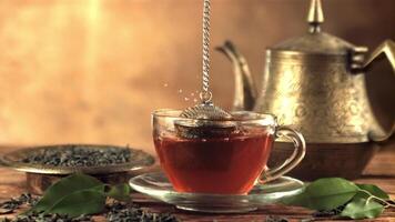 Super slow motion from the cup with tea get a sieve with brewing. On a brown background.Filmed on a high-speed camera at 1000 fps. video