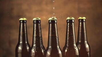 Super slow motion on closed glass beer bottles dripping water. On a brown background. Filmed on a high-speed camera at 1000 fps. video