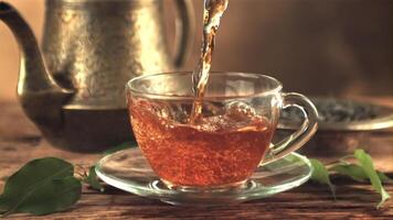 A super slow motion jet of tea pours into a cup of air bubbles. On a brown background. Filmed on a high-speed camera at 1000 fps. video