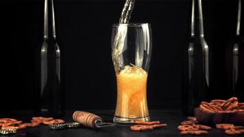 súper lento movimiento en el vaso vierte Fresco cerveza con aire burbujas en un negro fondo.filmado en un alta velocidad cámara a 1000 fps. video