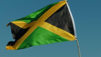 jamaica flagga vinka med blå himmel bakgrund video