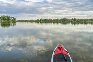 estar arriba paddleboard en lago foto