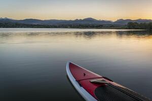 estar arriba paddleboard en lago foto