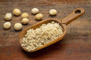 macadamia nut flour in wooden scoop photo