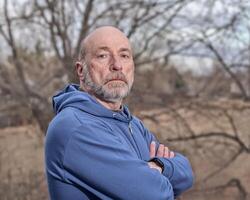 casual backyard portrait of a senior, confident, serious man photo