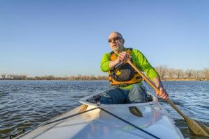 senior male is paddling expedition canoe photo