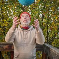 senior man is exercising with a heavy slam ball photo