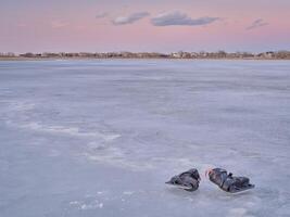 pair of men ice skates on a frozen lake photo