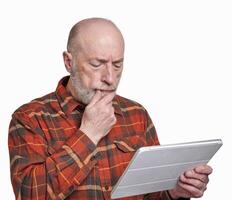 senior man is reading news on a digital tablet photo