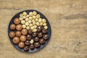 macadamia nuts on a black plate photo