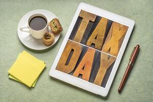 tax day in vintage wood type on tablet photo