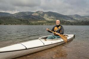 senior male is paddling expedition canoe photo