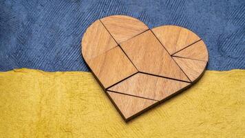 heart tangram against paper abstract in blue and yellow photo