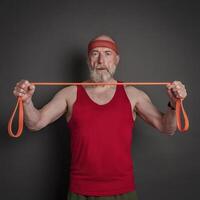 senior man is exercising with resistance band photo