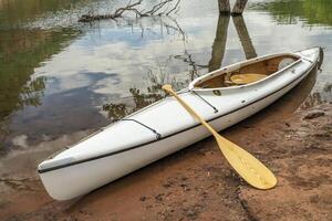 decked expedition canoe with a wooden paddle photo