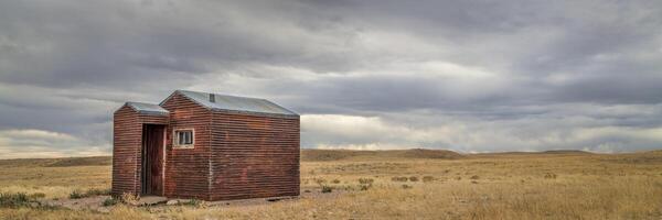 old, metal, rusty shack on a prairie photo