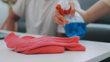 Woman cleaning table using rag and diffuser at home. video