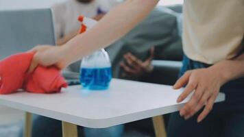 Woman cleaning table using rag and diffuser at home. video