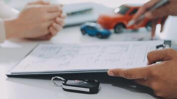 Man signing car insurance document or lease paper. Writing signature on contract or agreement. Buying or selling new or used vehicle. Car keys on table. Warranty or guarantee. Customer or salesman. video