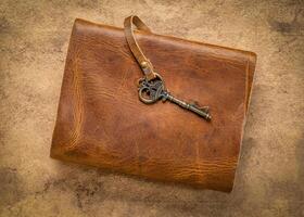 retro leather-bound journal with a decorative key on a handmade bark paper, journaling concept photo