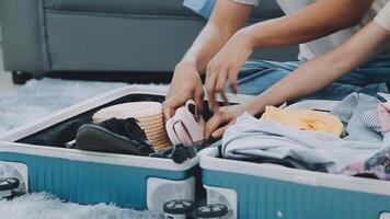 Asian woman prepare to pack clothes travel places with her friends. Asian beautiful two women friend pack things in your travel bag for holidays for her vacation trip video