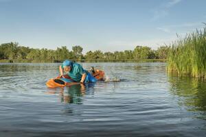 athletic, senior man is paddling a prone kayak photo