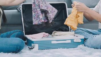 Asian woman prepare to pack clothes travel places with her friends. Asian beautiful two women friend pack things in your travel bag for holidays for her vacation trip video