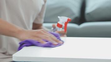 Woman cleaning table using rag and diffuser at home. video