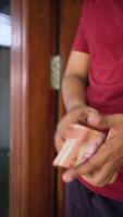 contando indonesio dinero con idr 100,000 dinero en efectivo. suave atención y selectivo enfocar. cerca arriba. video