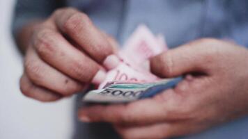 hand- Holding en tellen Indonesisch roepia idr rood 100.000 en blauw 50.000 bankbiljetten. video