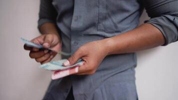 Hand holding and counting indonesian rupiah IDR red 100,000 and blue 50,000 Banknotes. video