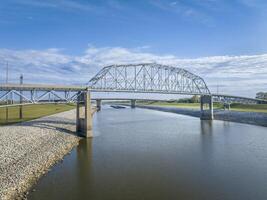 bridges and towboats with barges on Chain of Rock Bypass Canal of Mississippi River above St Louis, aerial view in October scenery photo