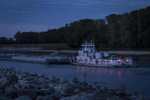 towboat with barges on Chain of Rock Bypass Canal of Mississippi River above St Louis, night scenery at dawn photo