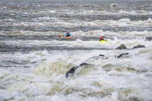 dos agua Blanca kayakistas jugando y formación abajo bajo agua represa en el Misisipí río a cadena de rocas cerca S t luis, Misuri foto