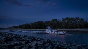towboat with barges on Chain of Rock Bypass Canal of Mississippi River above St Louis, night scenery at dawn photo