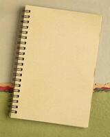 blank spiral sketchbook against colorful abstract paper landscape photo
