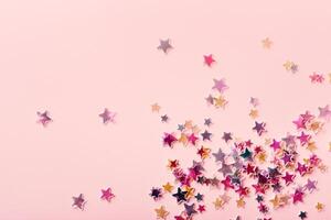 Pink and yellow pastel Stars Glitter Confetti on pink background. Festive backdrop photo