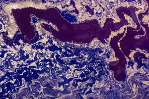 Acrylic Fluid Art. Purple Waves Pattern with Gold sparkles on blue background. Abstract marble background or texture photo