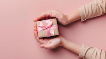 Child holding gift box on soft pink background, isolated on pink background photo