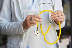 Female doctor holding a stethoscope. Concept for health and medicine. Hospital background. photo