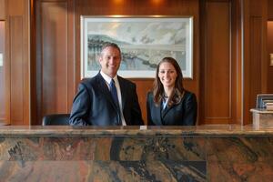 Portrait of two receptionist in uniform at desk in luxury hotel lobby. Occupation concept. photo