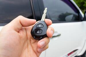 coche llave en mano con coche en el antecedentes. coche cosas concepto. después algunos ediciones foto