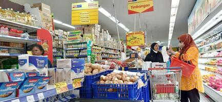 cliente elegir varios comestibles productos en tienda de comestibles almacenar. supermercado concepto. bekasi, Oeste Java, Indonesia - marzo 8 2024 foto