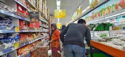 cliente elegir varios comestibles productos en tienda de comestibles almacenar. supermercado concepto. bekasi, Oeste Java, Indonesia - marzo 8 2024 foto